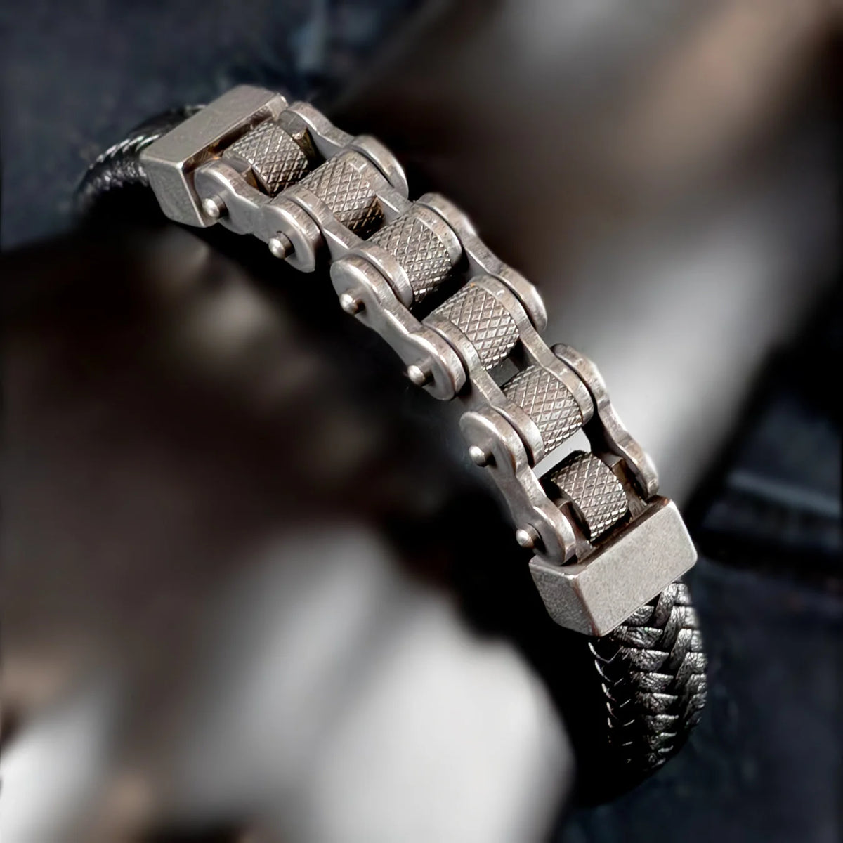 Metallic bracelet with a bike chain-inspired design and textured cylindrical links.