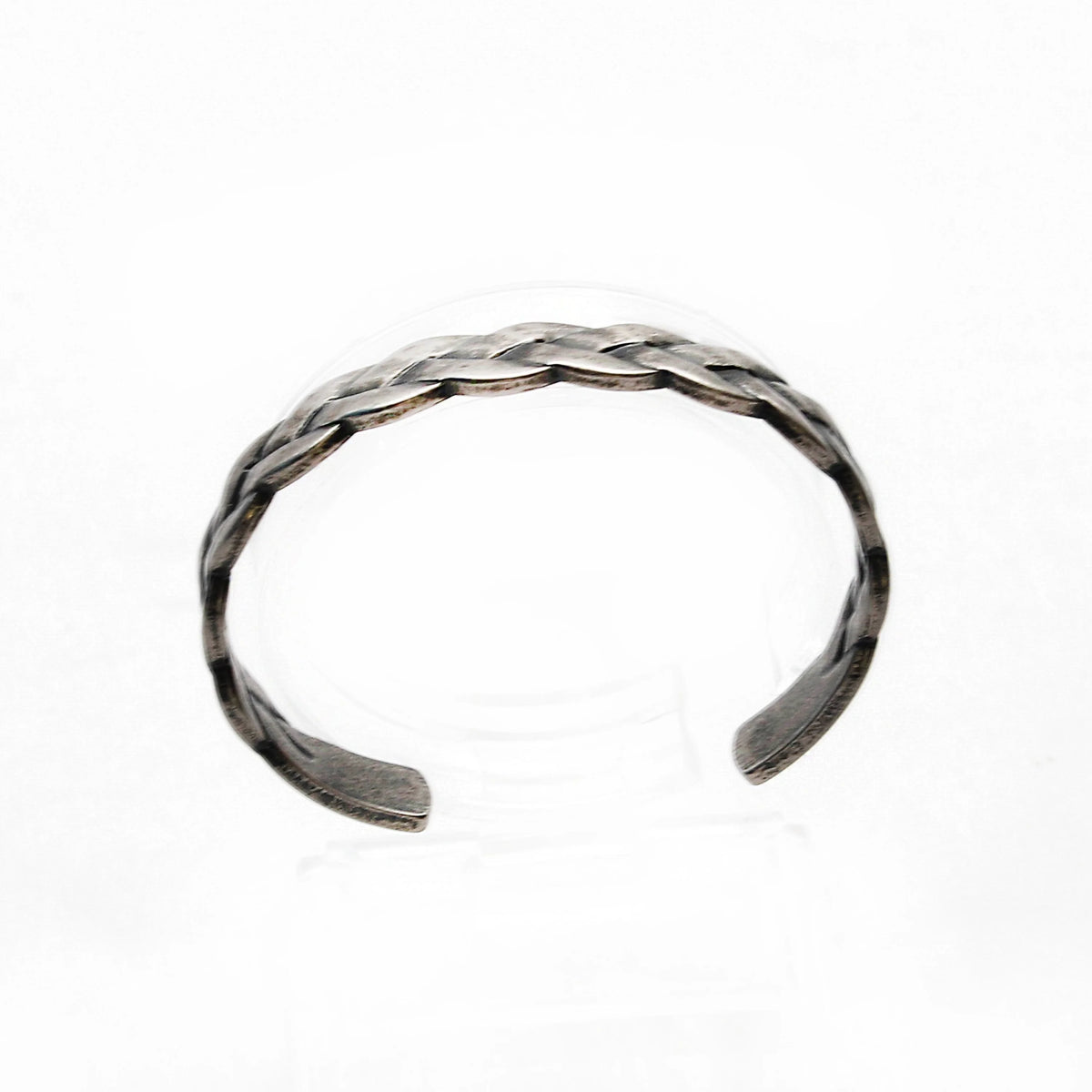 Braided silver cuff bracelet with an open design.