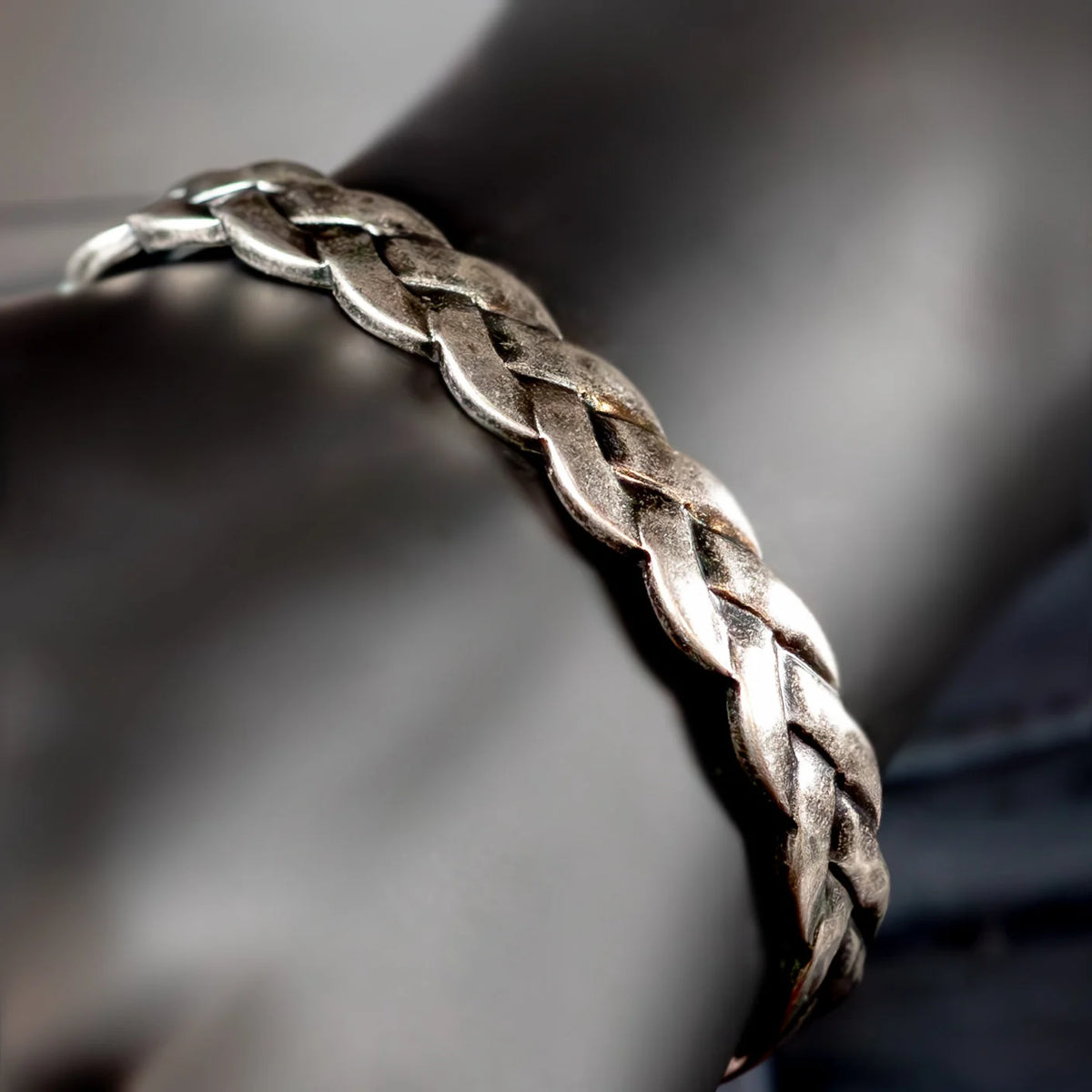 Silver braided bracelet or bangle with an intricate woven pattern.