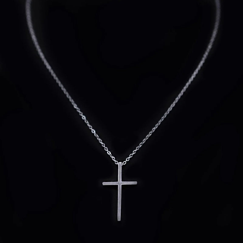 Silver cross pendant necklace on a delicate chain.