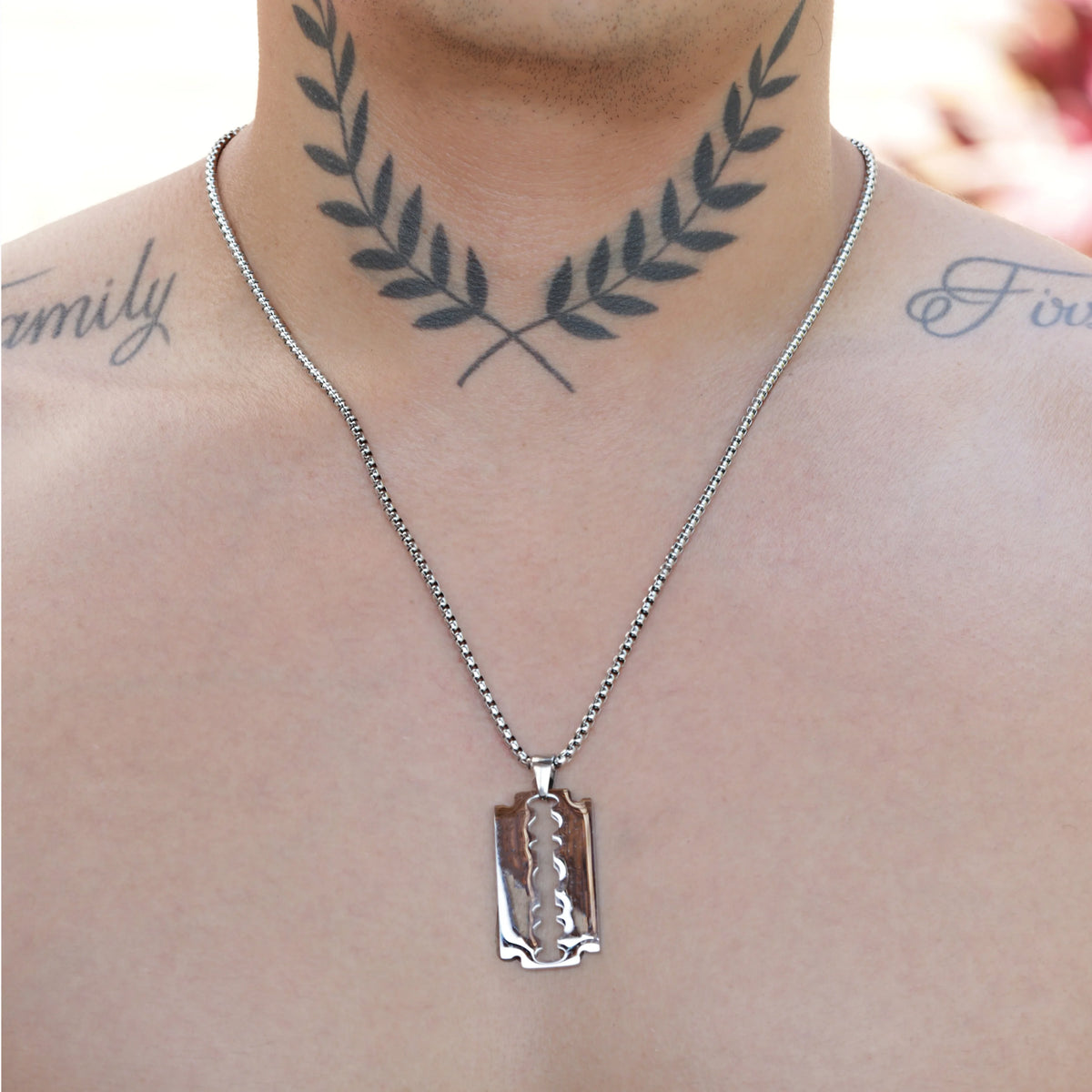 Razor blade pendant necklace on a silver chain.