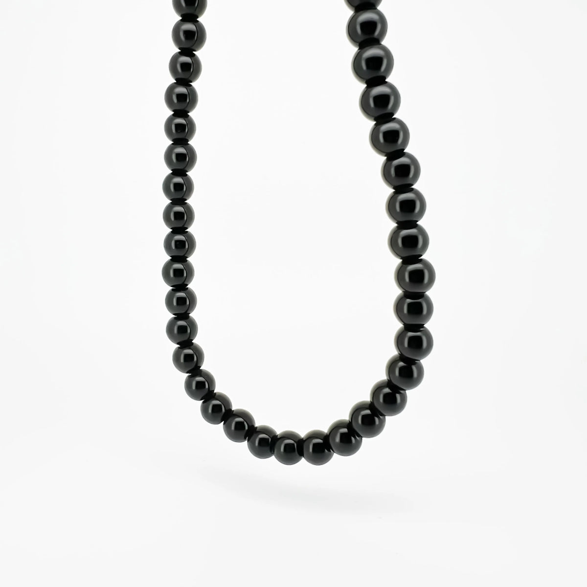 Black bead necklace with smooth, round stones.