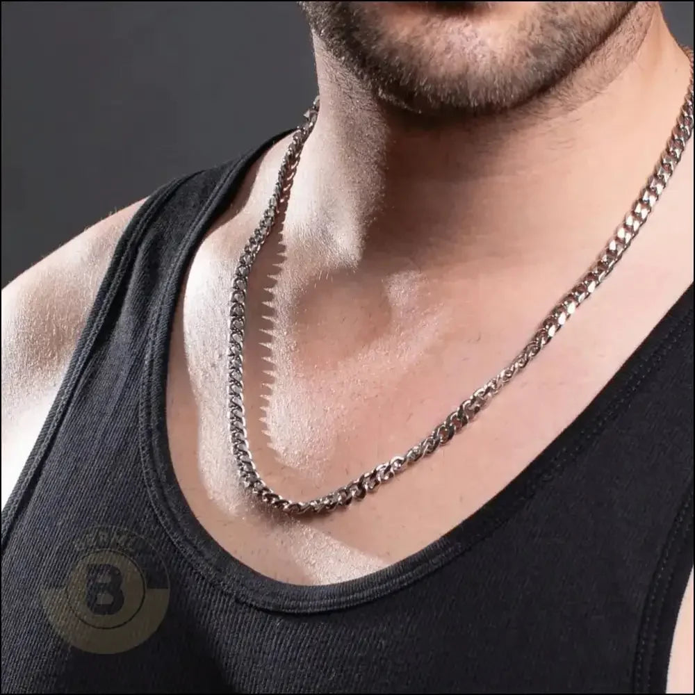 Silver chain necklace worn with a black tank top.