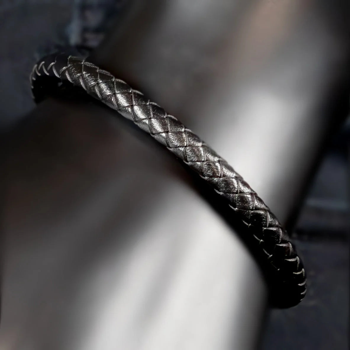 Braided leather bracelet with a metallic sheen.