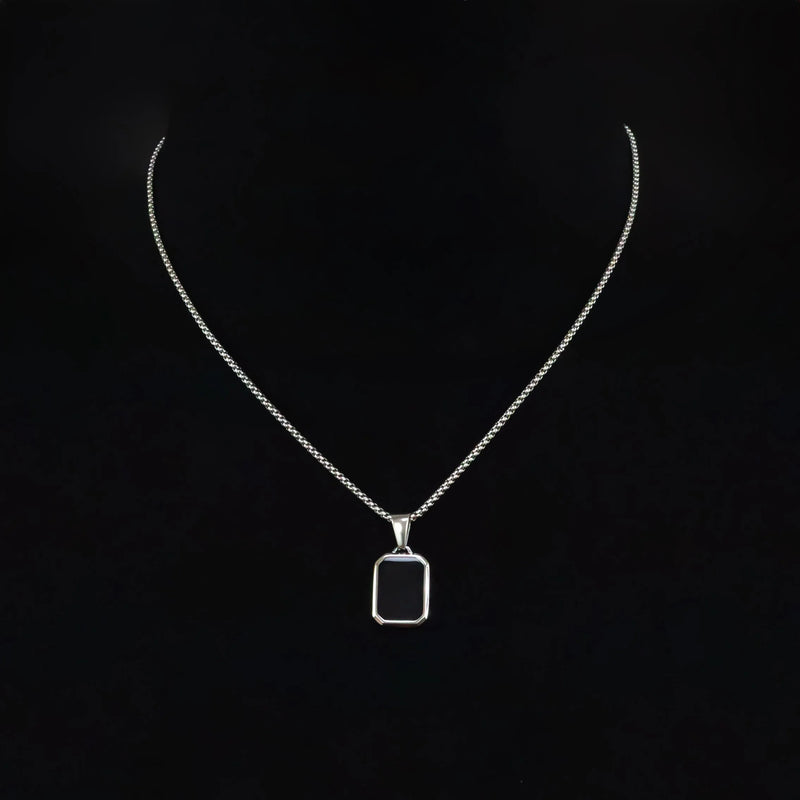 Silver necklace with a rectangular black pendant.