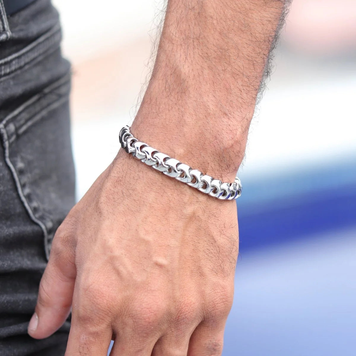 Silver chain bracelet worn on a person’s wrist.