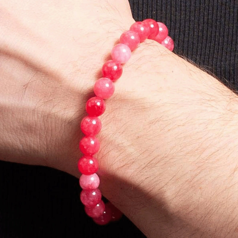 Pink beaded bracelet worn on a wrist.