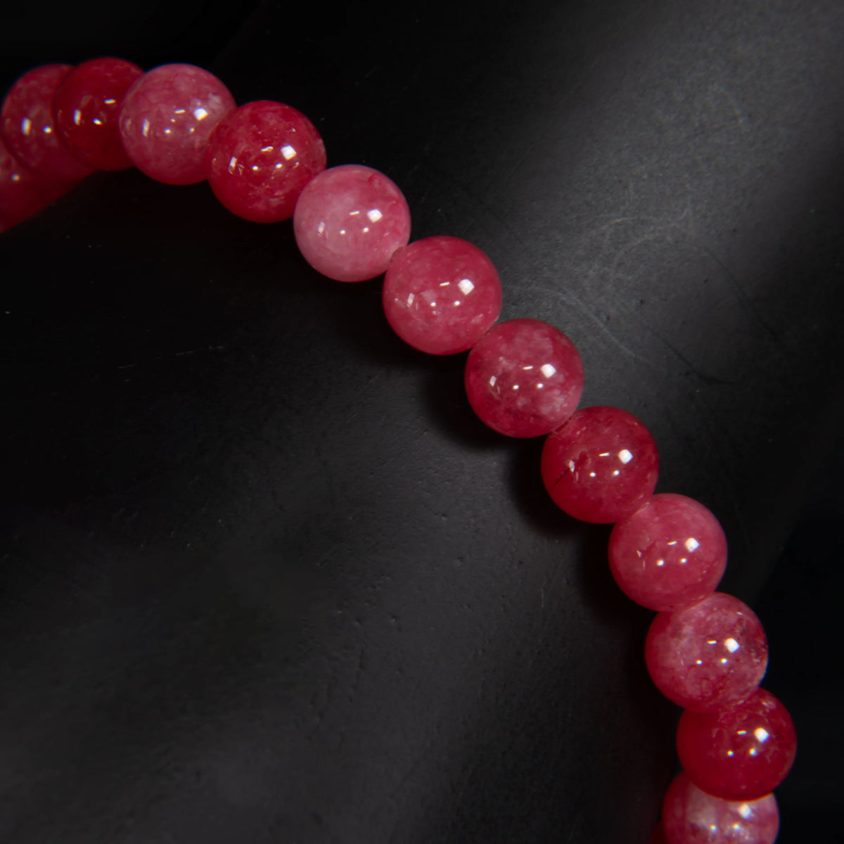 String of round, glossy red beads or gemstones.