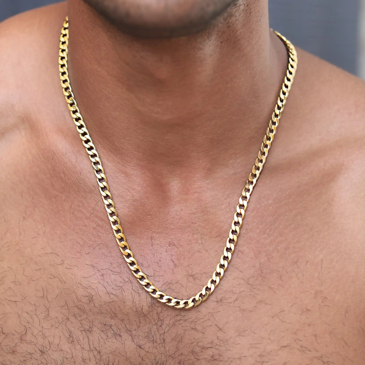 Gold-colored chain necklace with a Cuban link pattern.