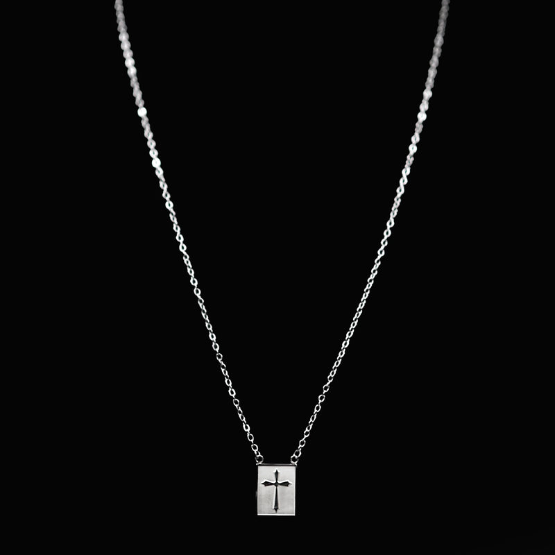 Silver necklace with a rectangular pendant featuring a cross design.