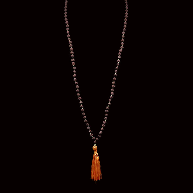 Beaded necklace with an orange tassel pendant.