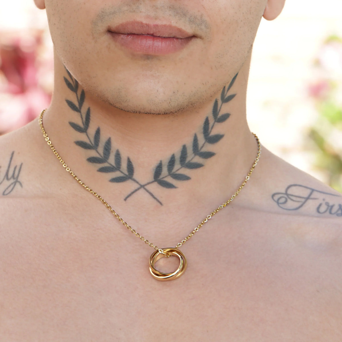 Gold-toned twisted ring pendant on a delicate chain necklace.