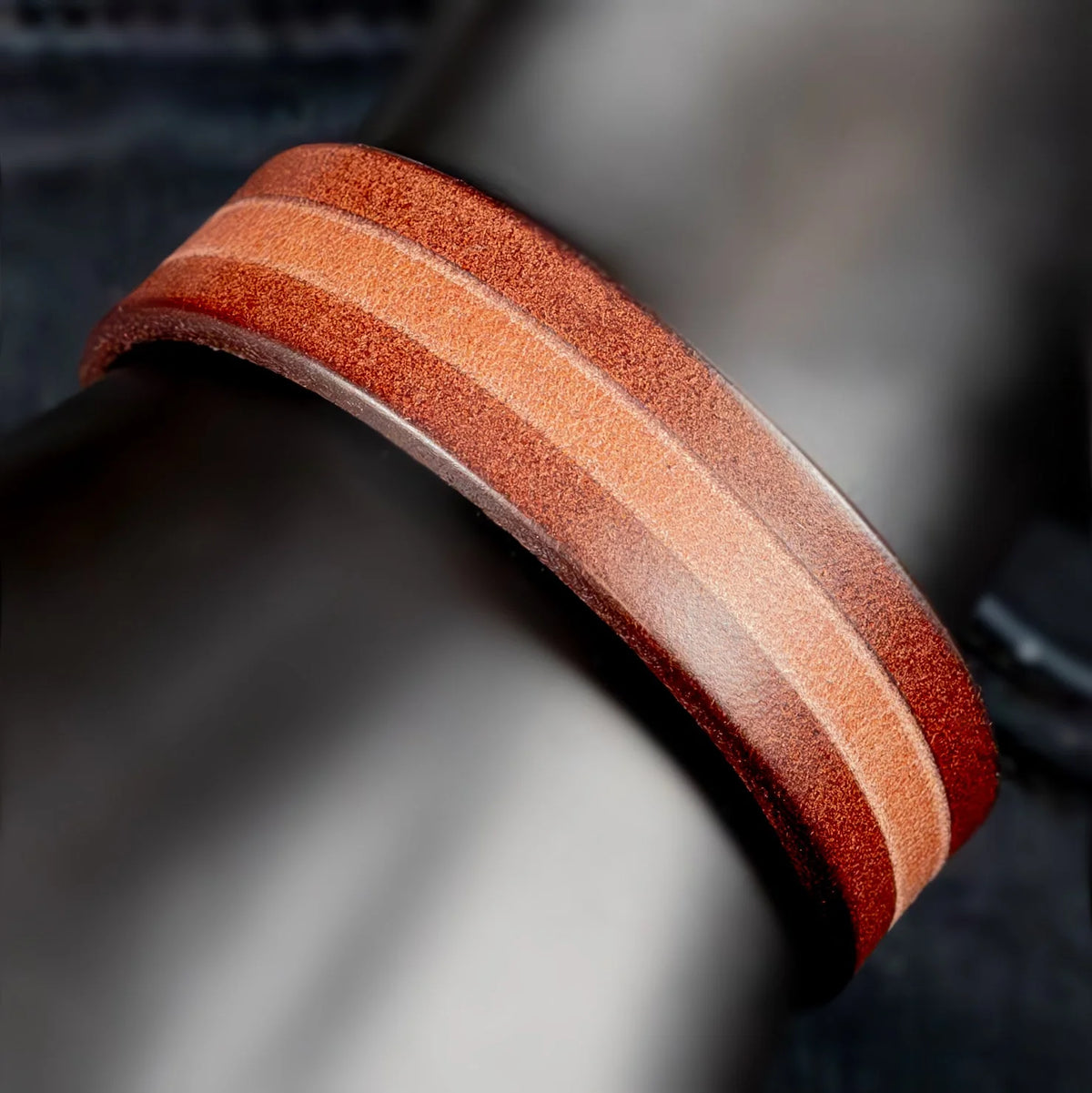 Curved wooden ring with alternating light and dark reddish-brown stripes.