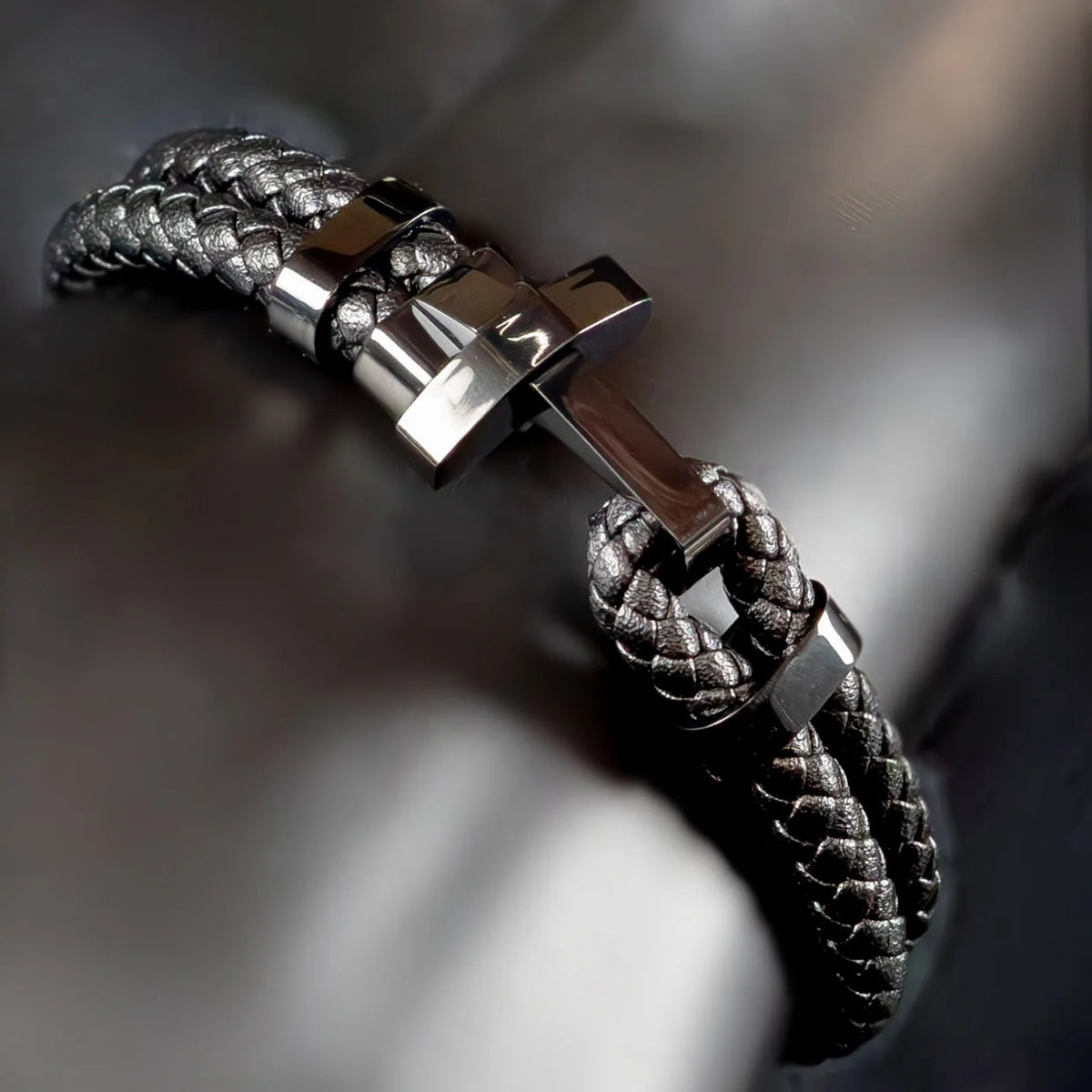 Braided leather bracelet with a sleek metal clasp.