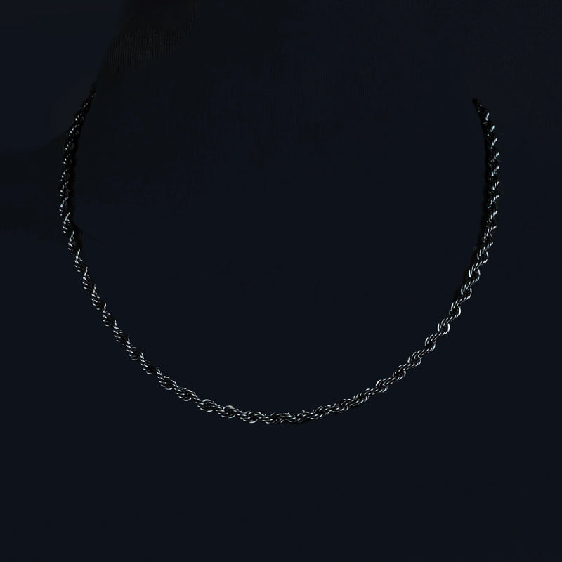 Silver twisted chain necklace against a dark background.