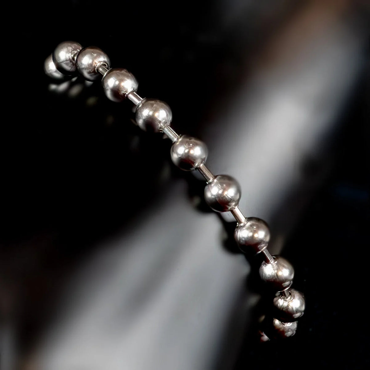 Metallic ball chain with spherical beads connected by small cylindrical links.