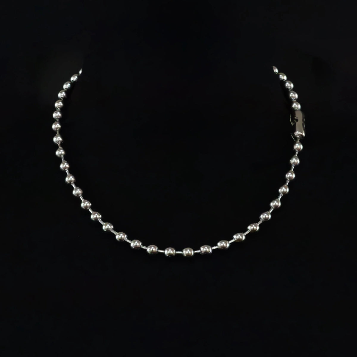 Silver beaded necklace or chain with a clasp visible on one end.