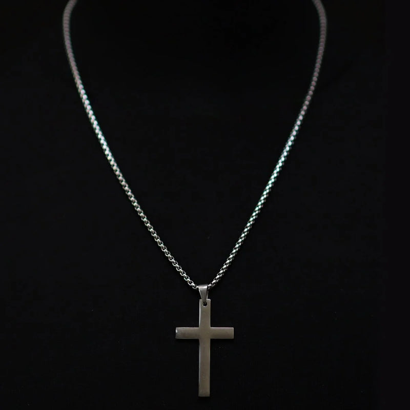 Silver cross pendant on a delicate chain necklace.