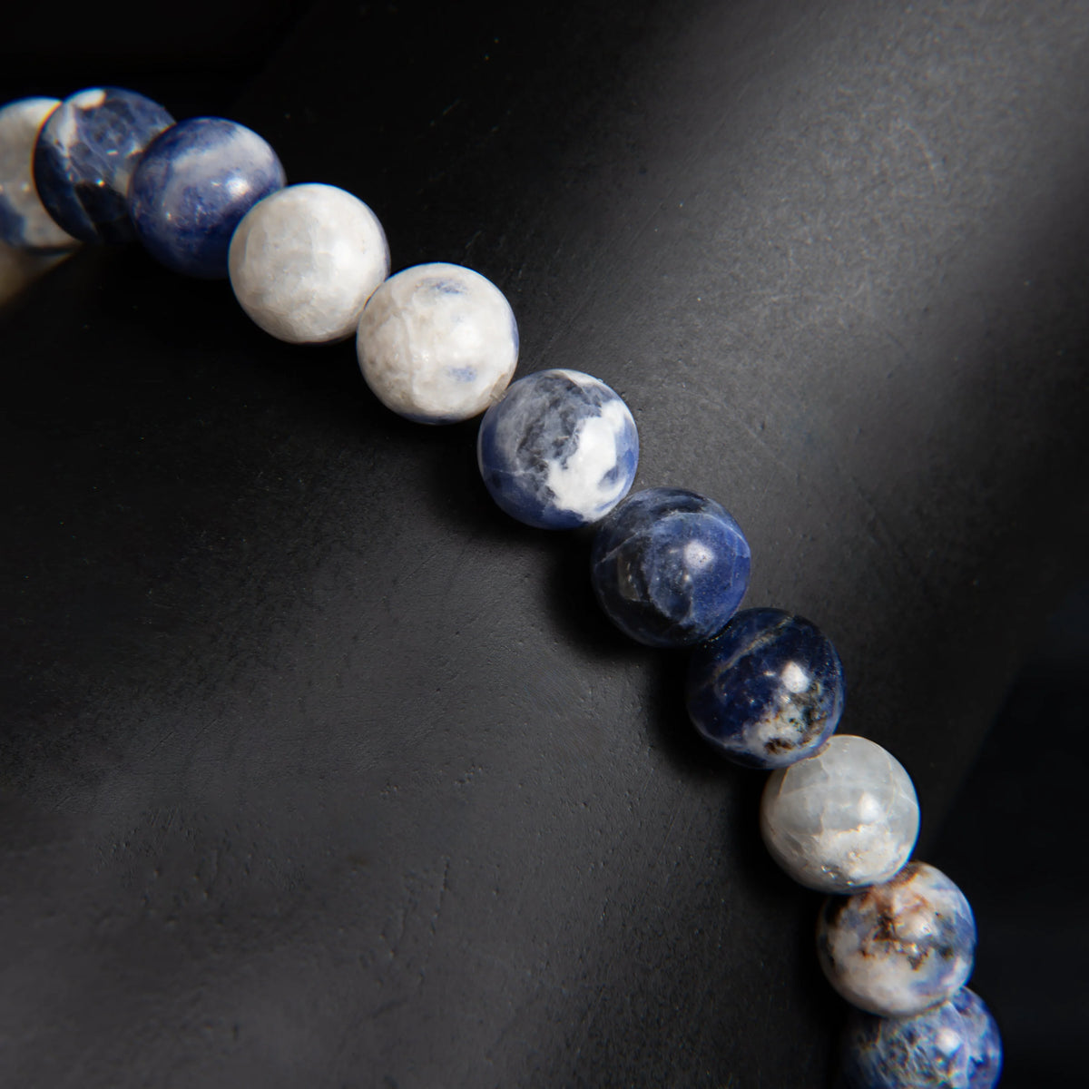 String of blue and white spherical beads resembling a bracelet or necklace.