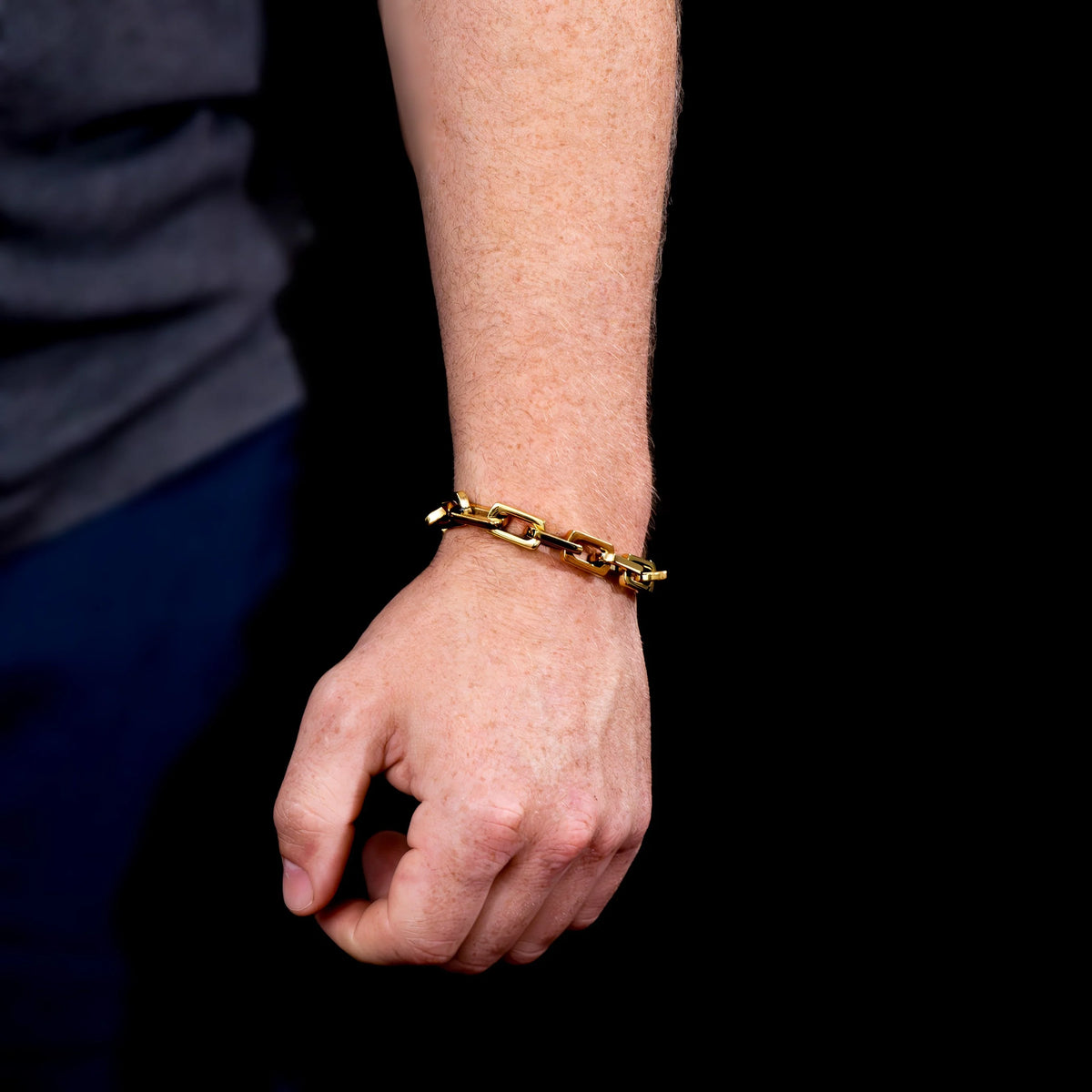 Gold chain-link bracelet worn on a wrist.