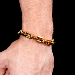 Gold chain-link bracelet worn on a wrist.