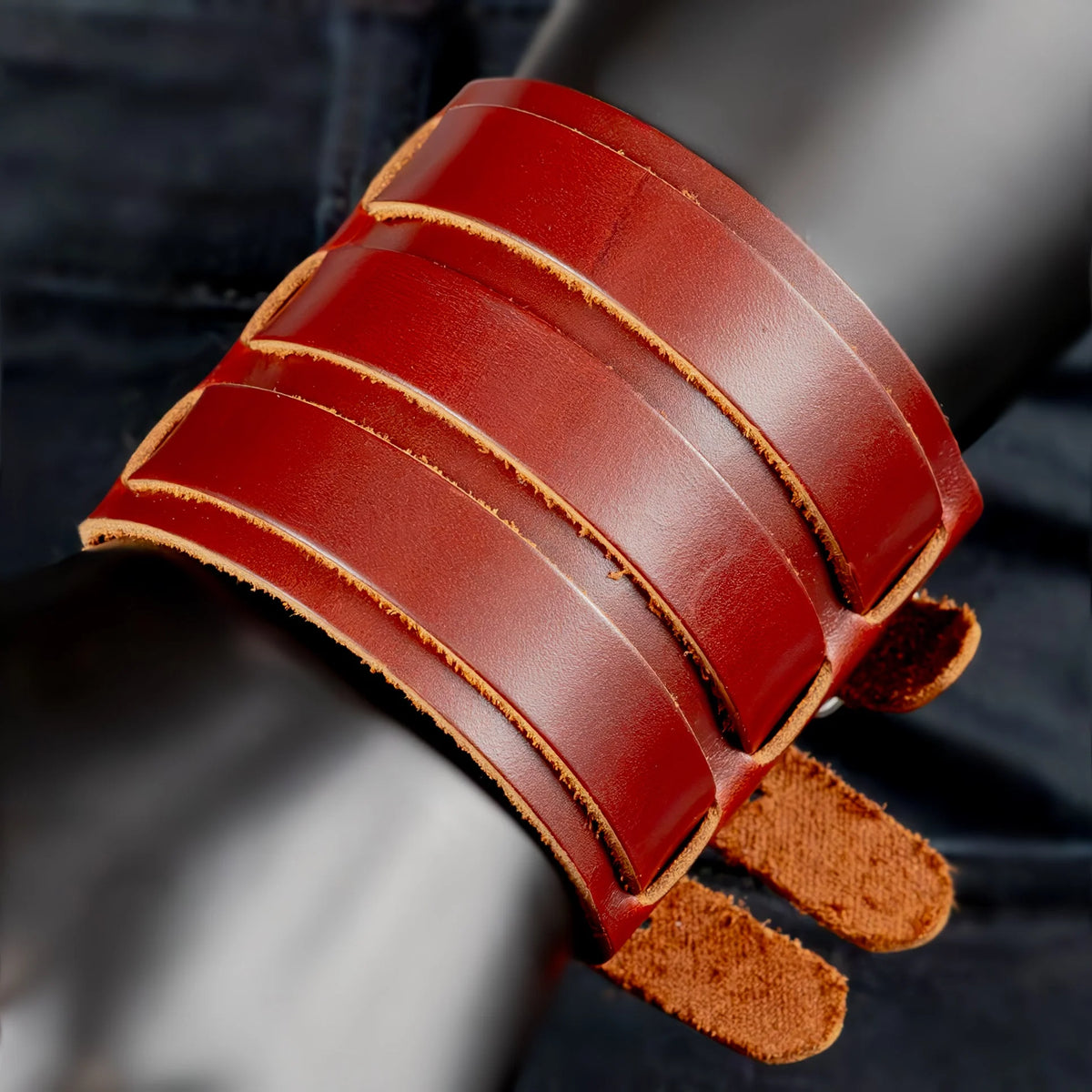 Red leather cuff bracelet with multiple straps and buckles.