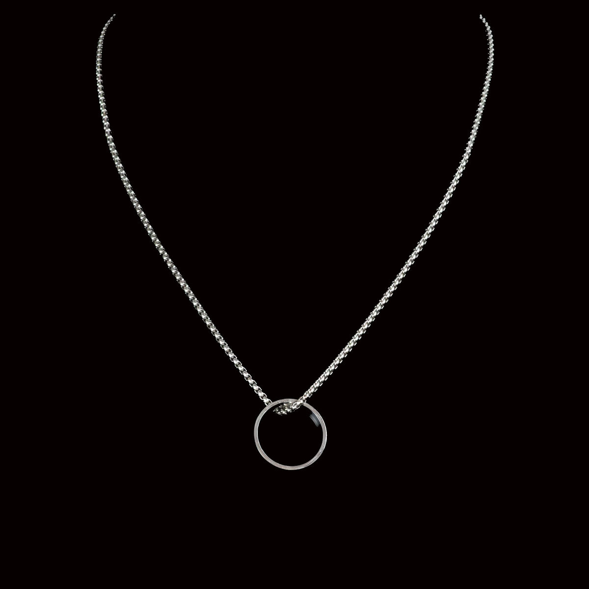 Silver necklace with a circular pendant.