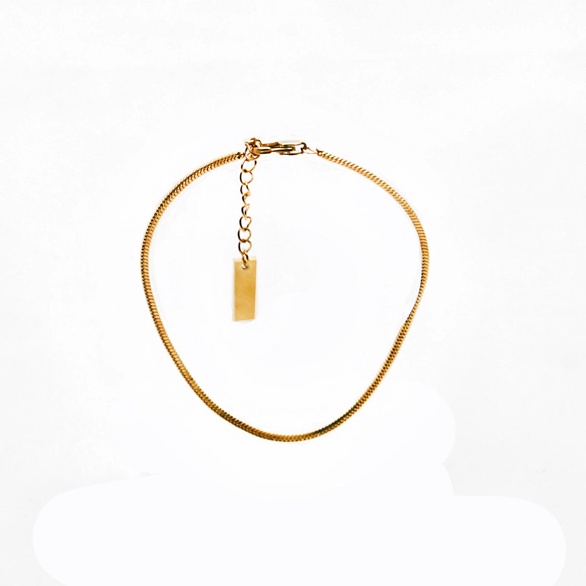 Gold-colored chain necklace with a small pendant tag.