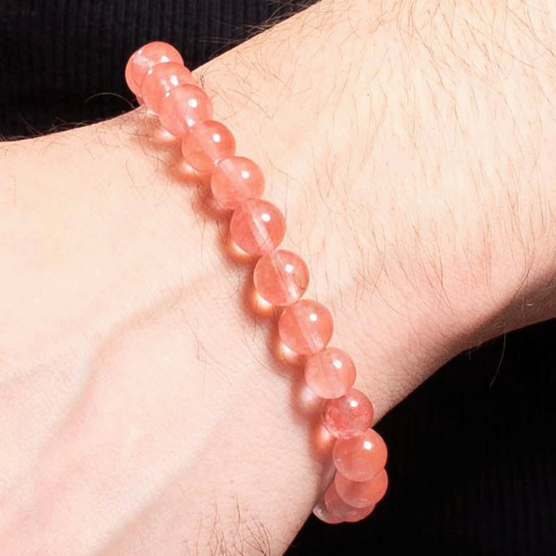 Pink gemstone or crystal bead bracelet worn on a wrist.