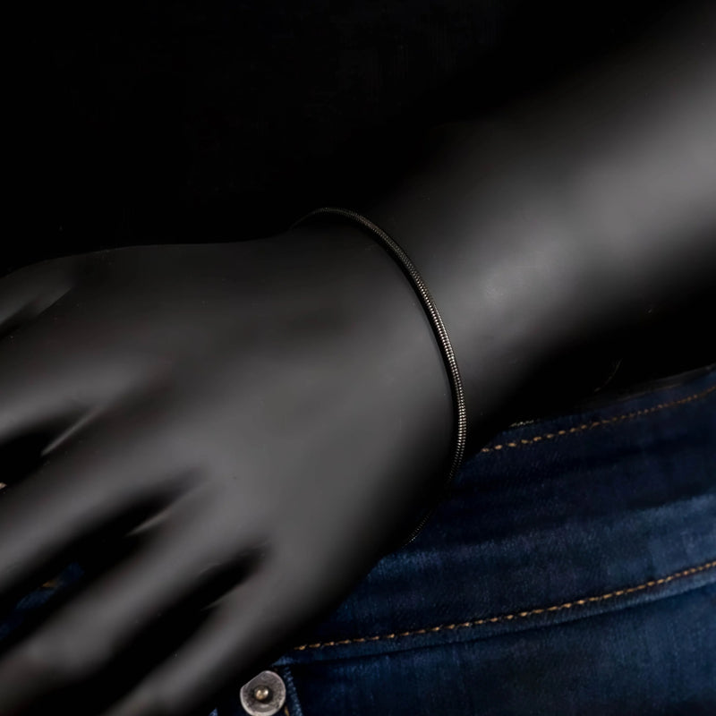 Black leather glove with a thin bracelet.