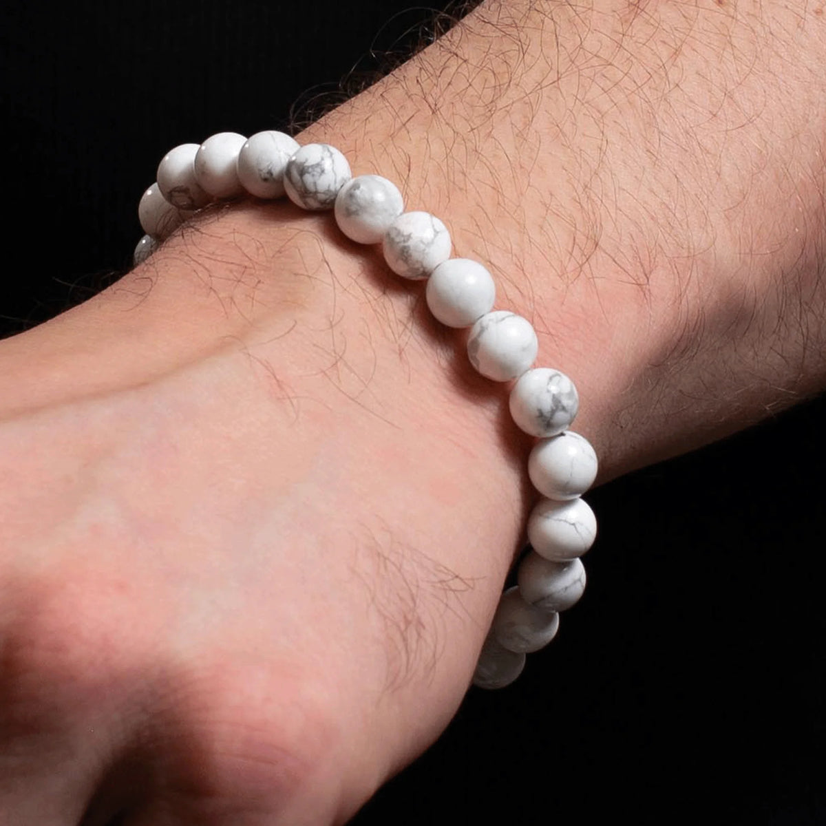 White beaded bracelet worn on a wrist.