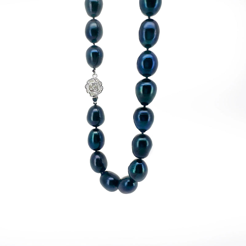 Pearl necklace with dark blue-green pearls and a silver floral clasp.