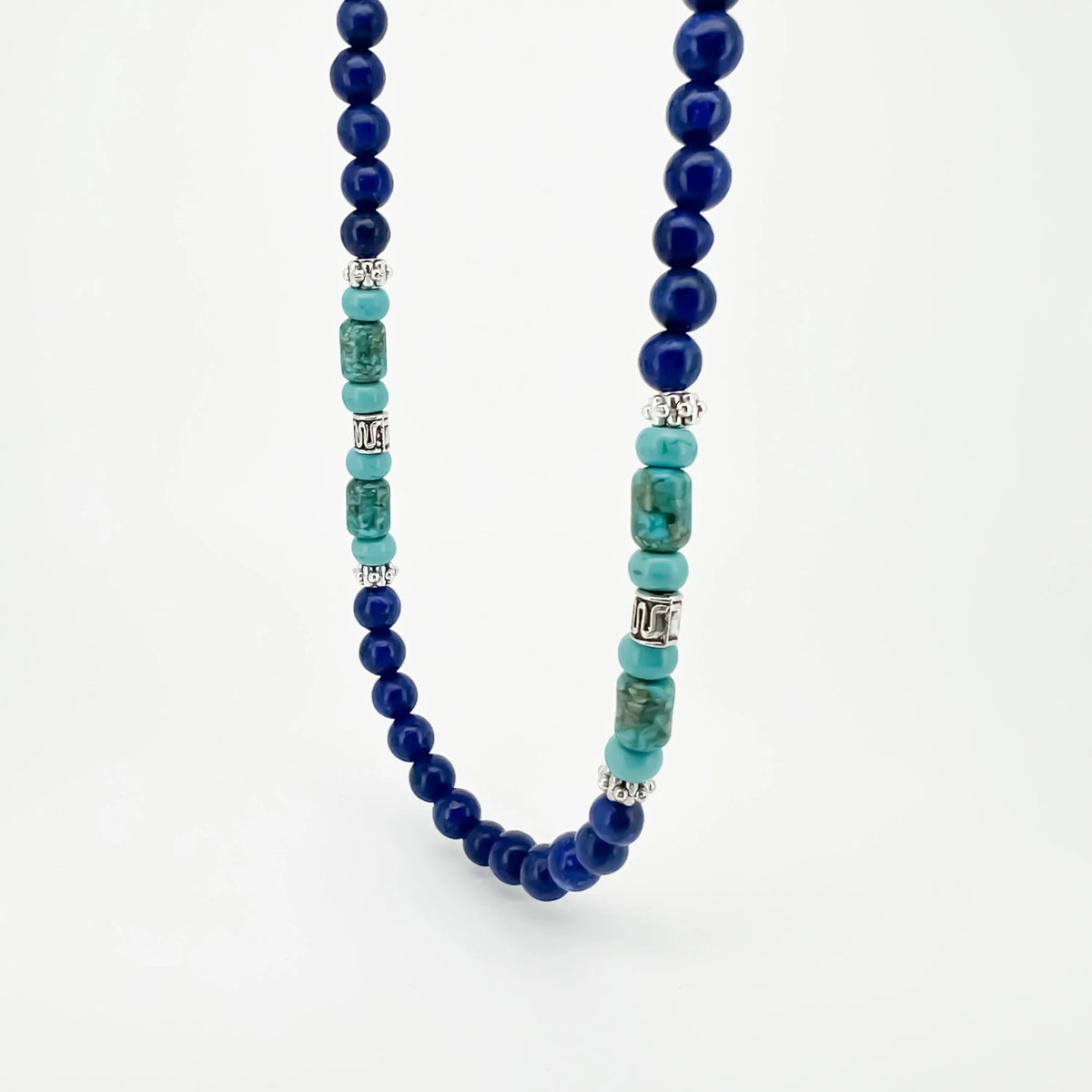 Beaded necklace featuring dark blue spheres and turquoise-colored cylindrical stones.