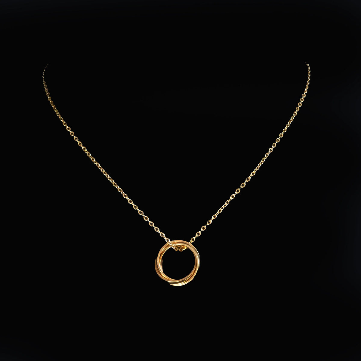 Gold necklace with a circular pendant.