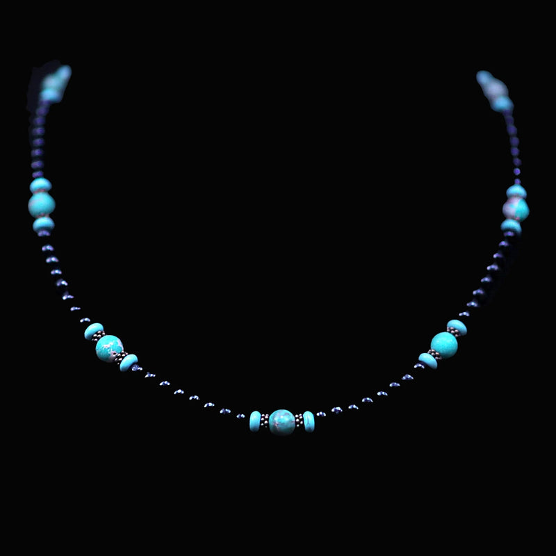 Turquoise and dark blue beaded necklace with decorative spacer beads.