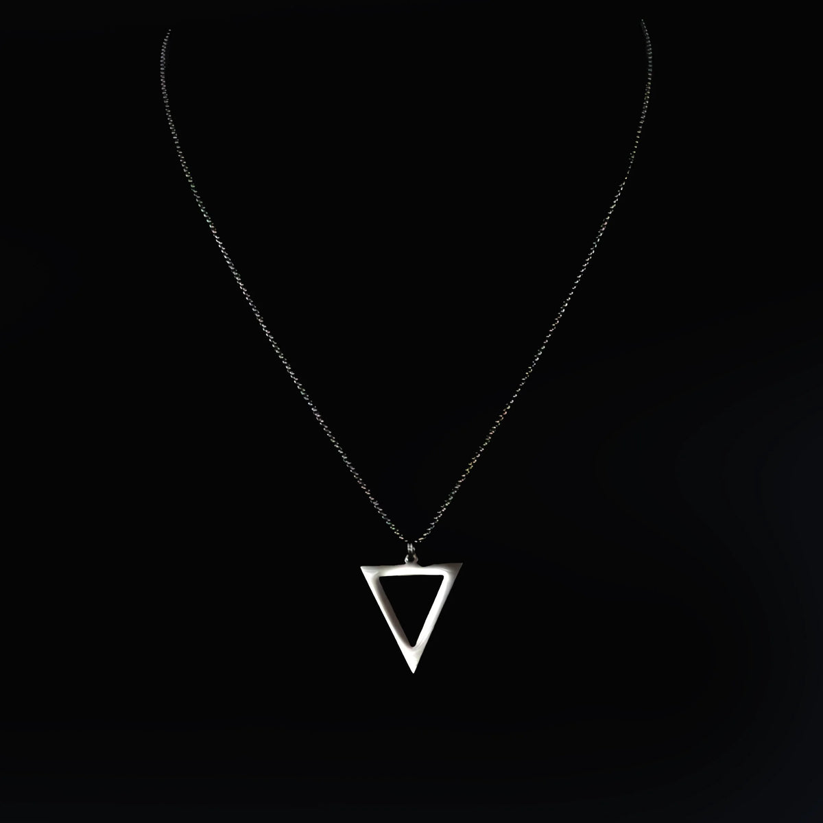 Silver triangular pendant on a delicate chain necklace.