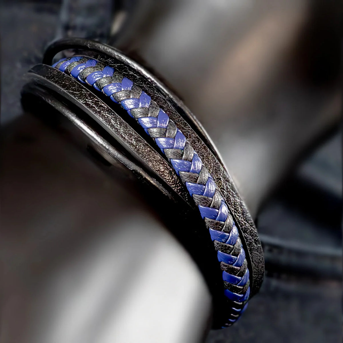 Leather bracelet with a blue and silver braided inlay.