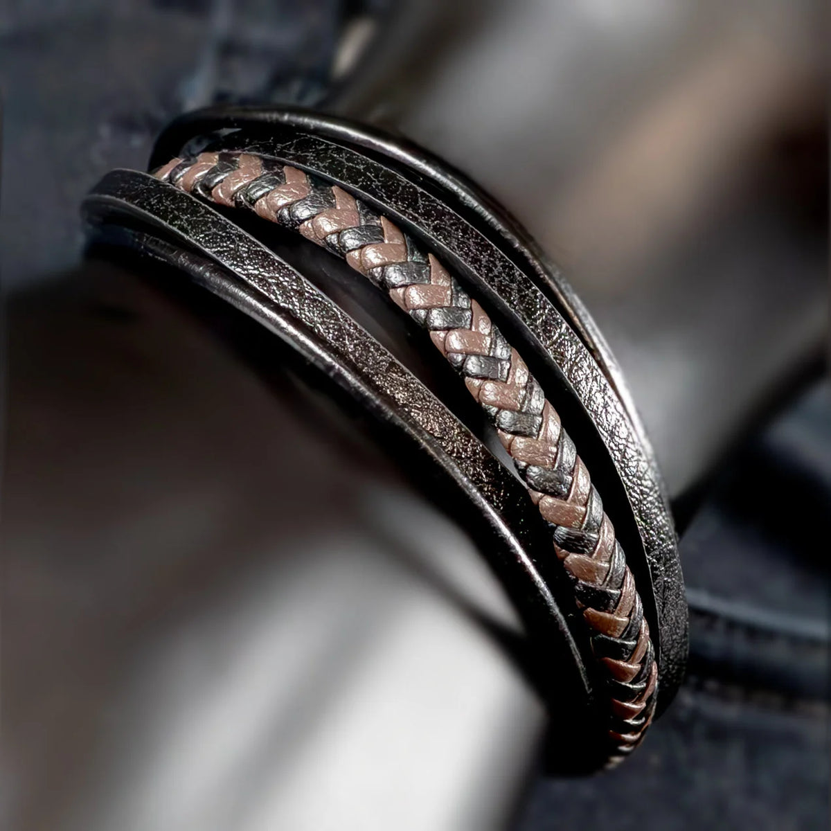 Intricately designed metal bracelet with a braided leather inlay.