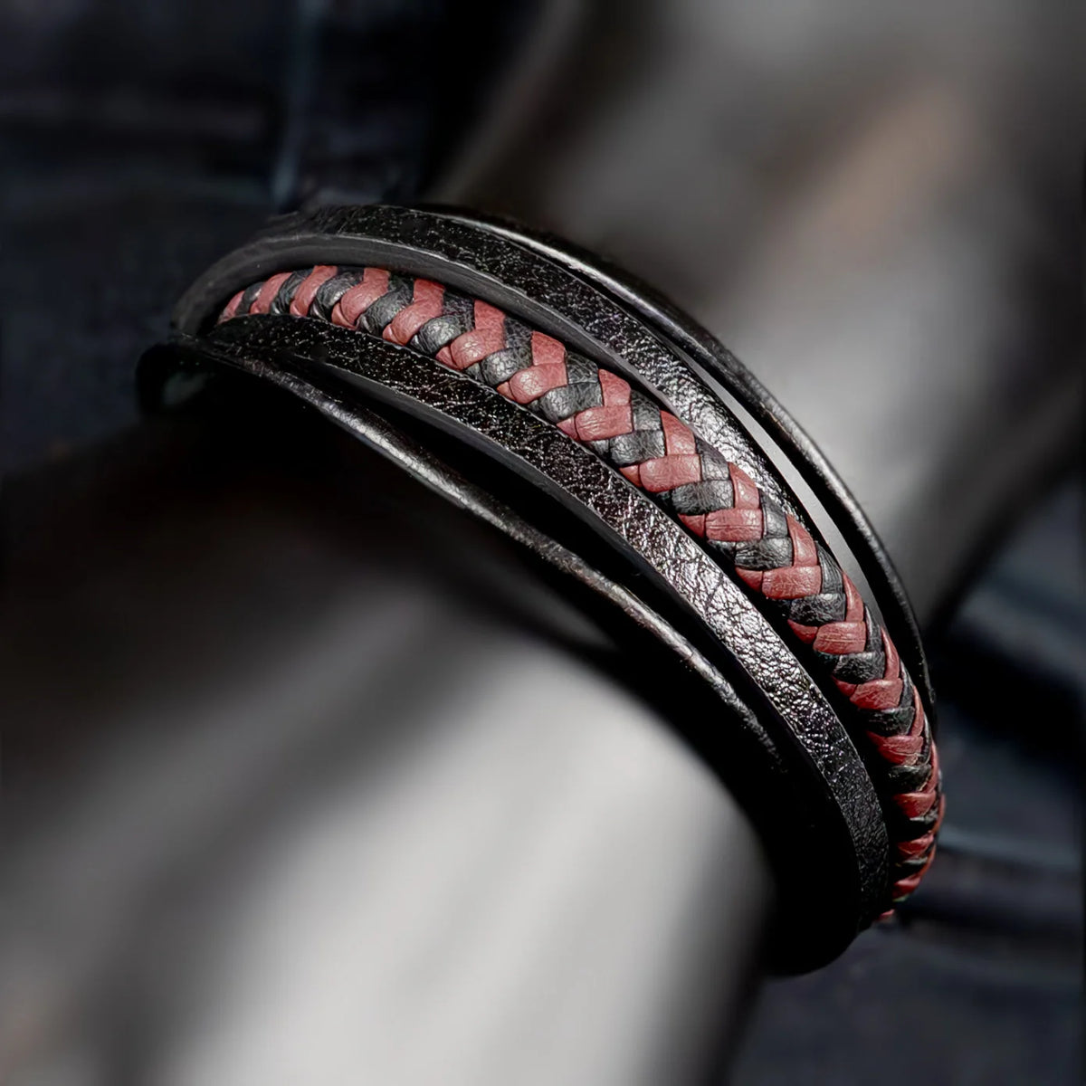 Leather bracelet with a red and black braided pattern inlay.