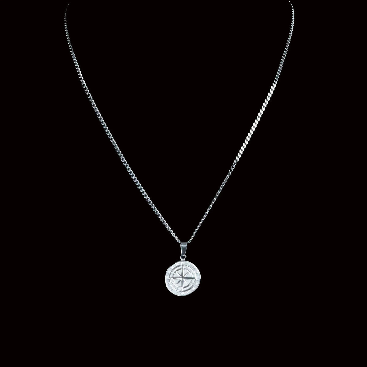 Silver compass pendant necklace on a delicate chain.