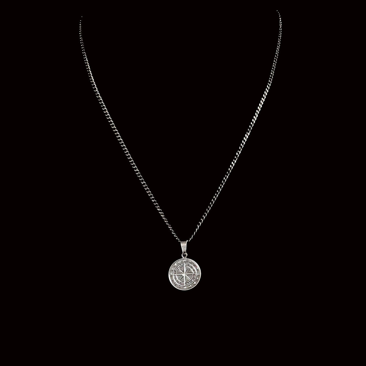 Silver pendant necklace with a circular medallion charm.