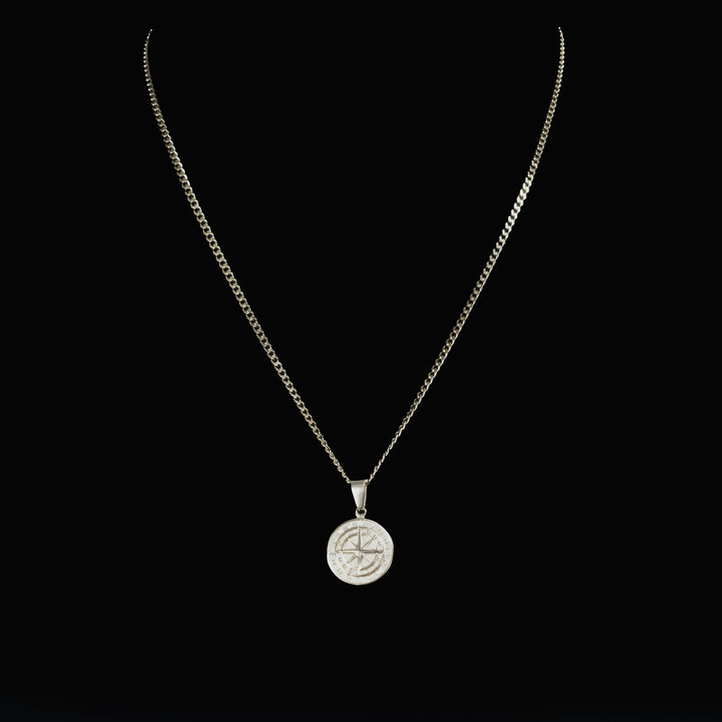 Silver necklace with a round pendant featuring a heart design.