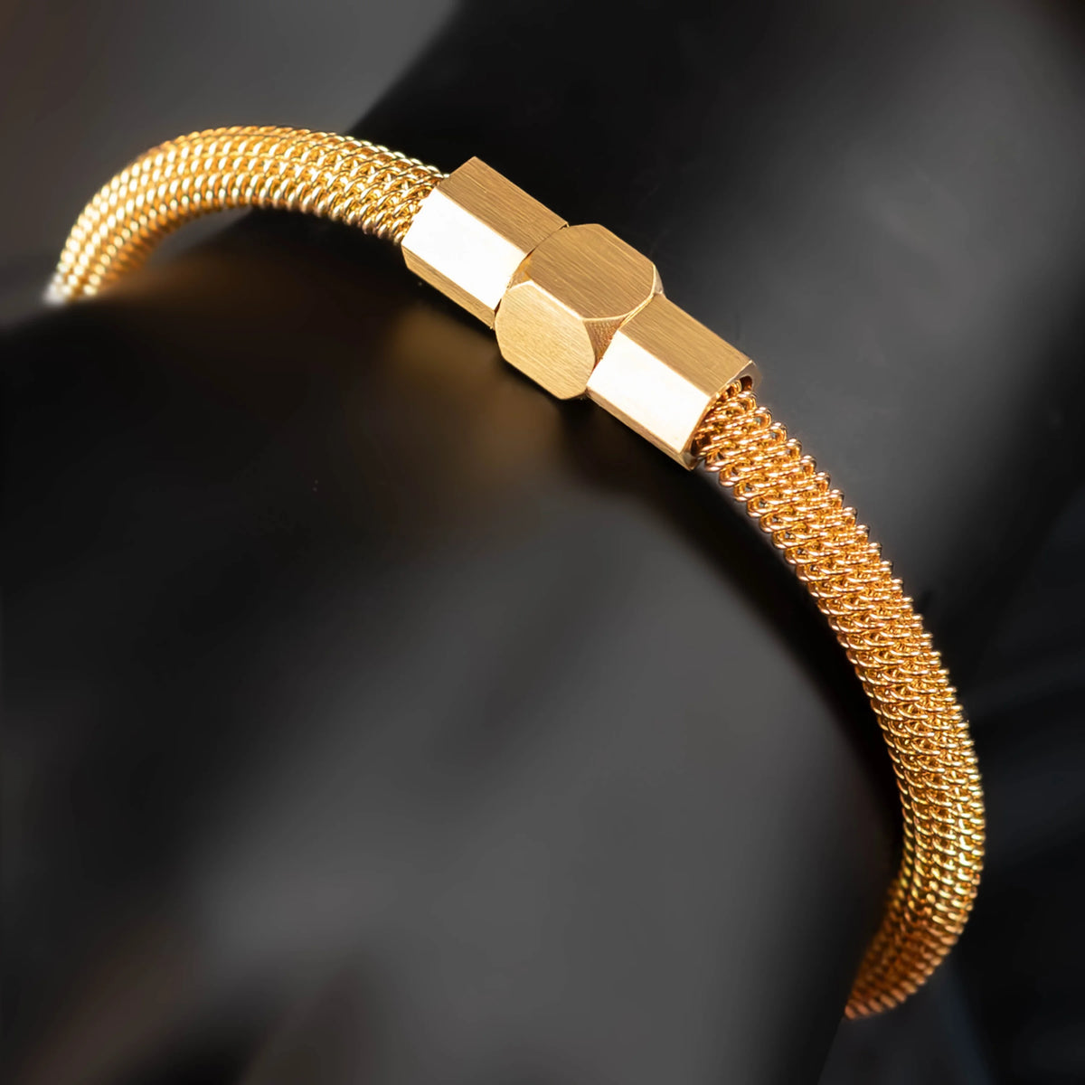 Gold-toned mesh bracelet with a hexagonal clasp.