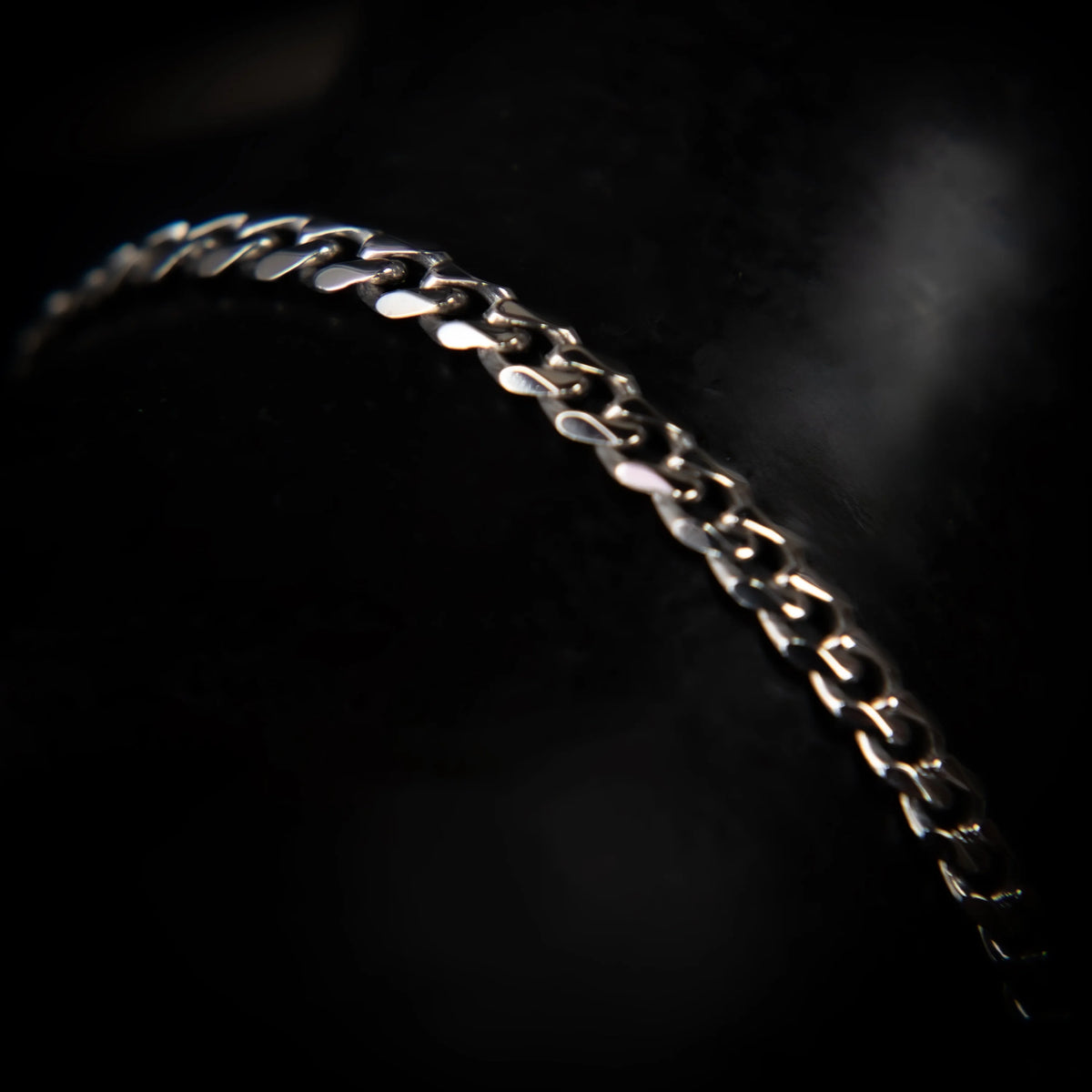 Curved silver chain bracelet with interlocking links.