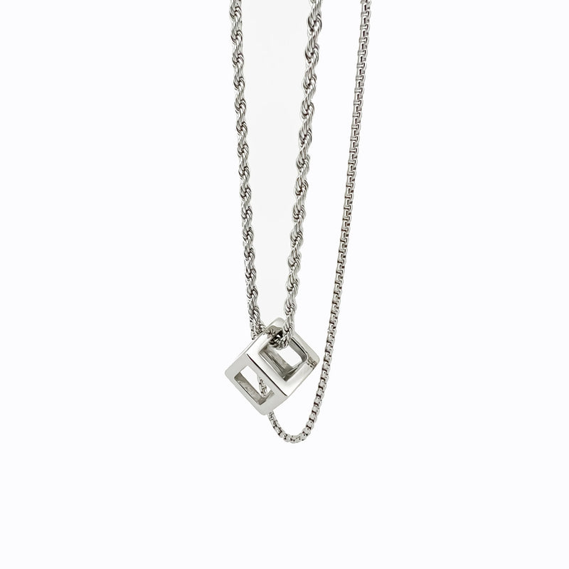 Silver necklace with a cube-shaped pendant on a twisted chain.