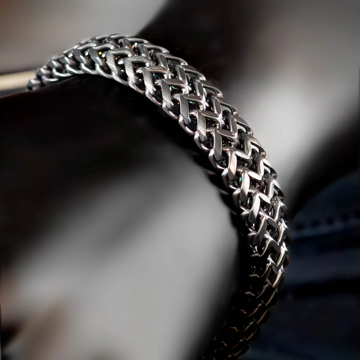 Intricately woven silver bracelet with a braided chain pattern.