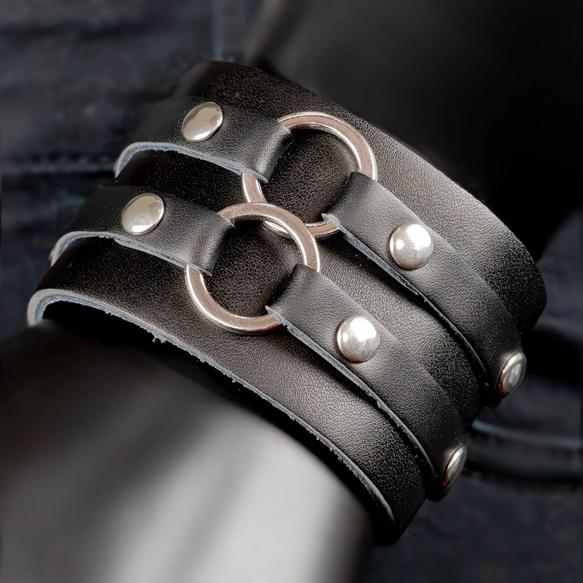 Black leather bracelet with metal rings and studs.