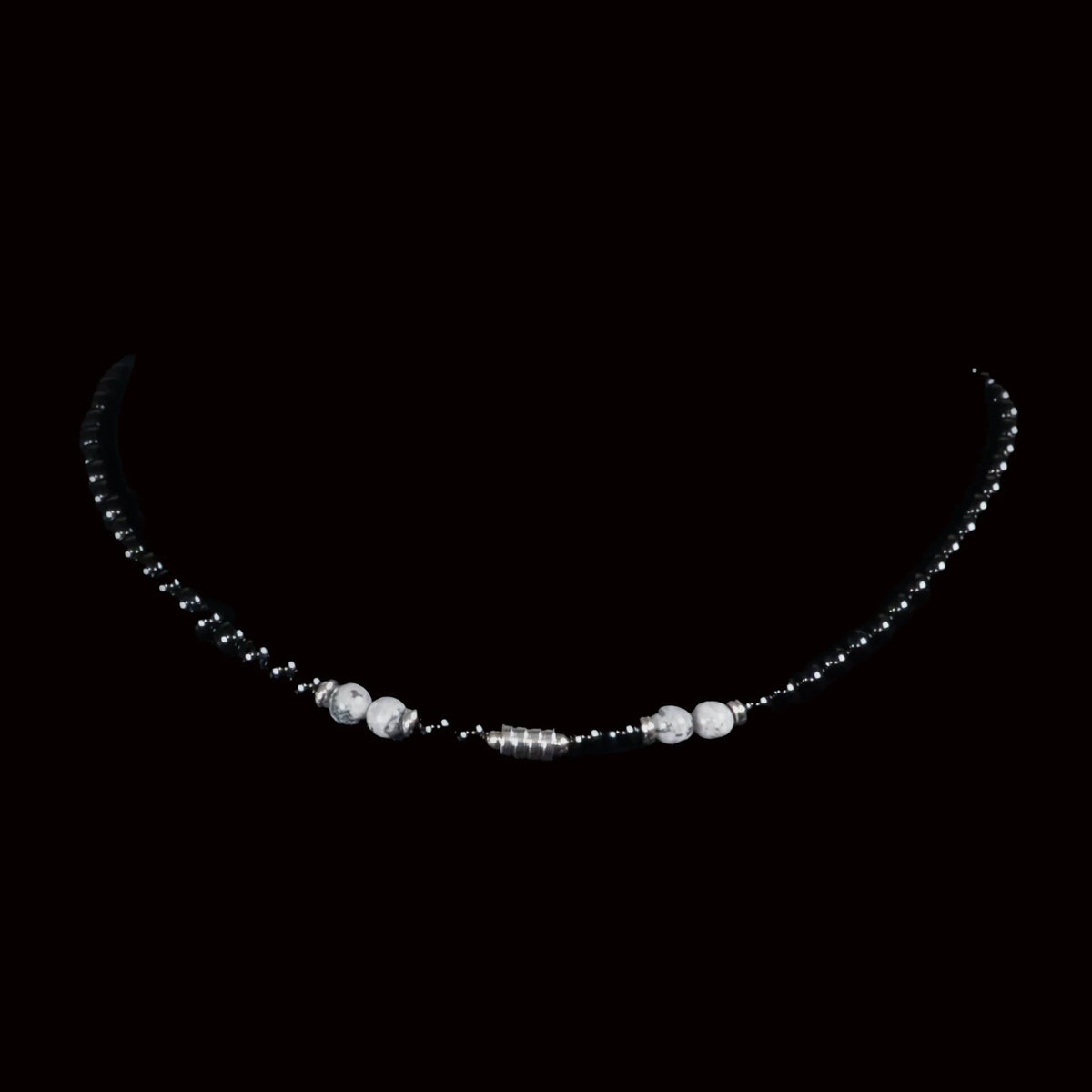 Delicate necklace with dark beads and white pearl accents.