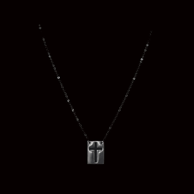 Silver pendant necklace featuring a cross design on a square plate.