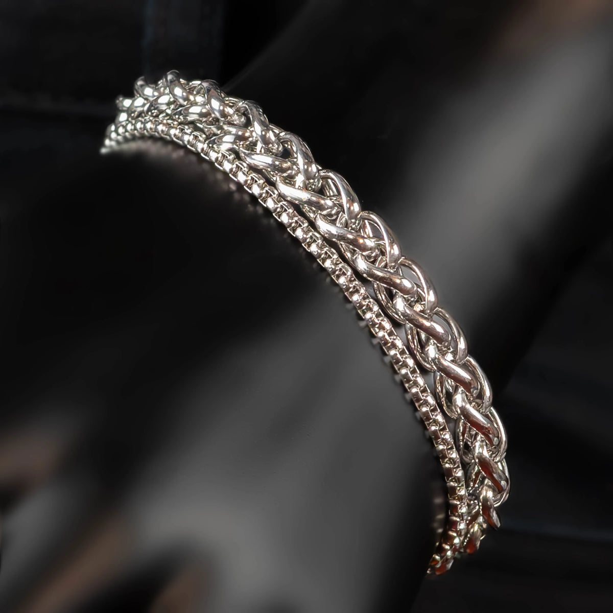 Intricately woven silver bracelet with a braided chain design.